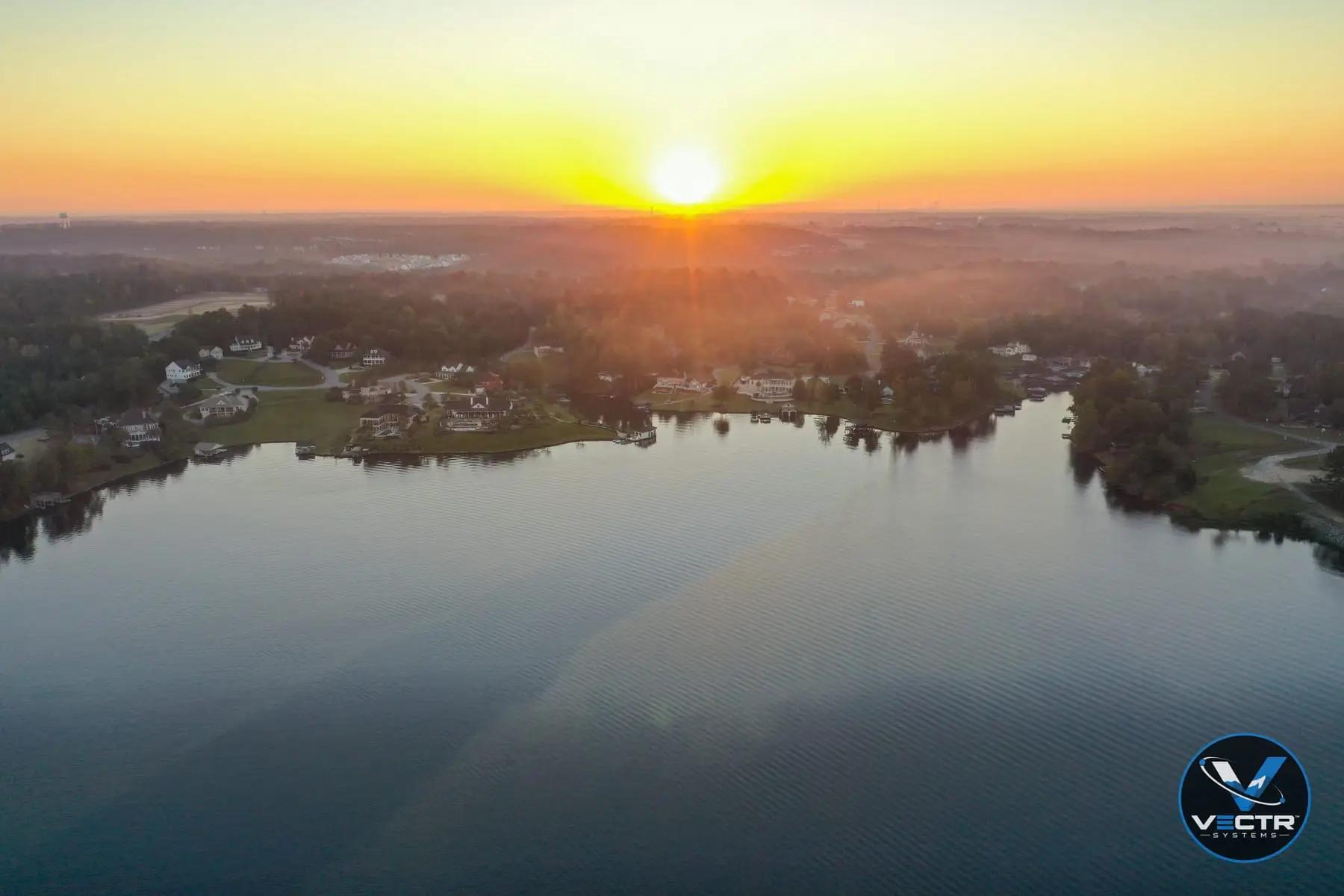 Aerial view of Lake Tobesofkee at sunrise with lakefront homes and docks